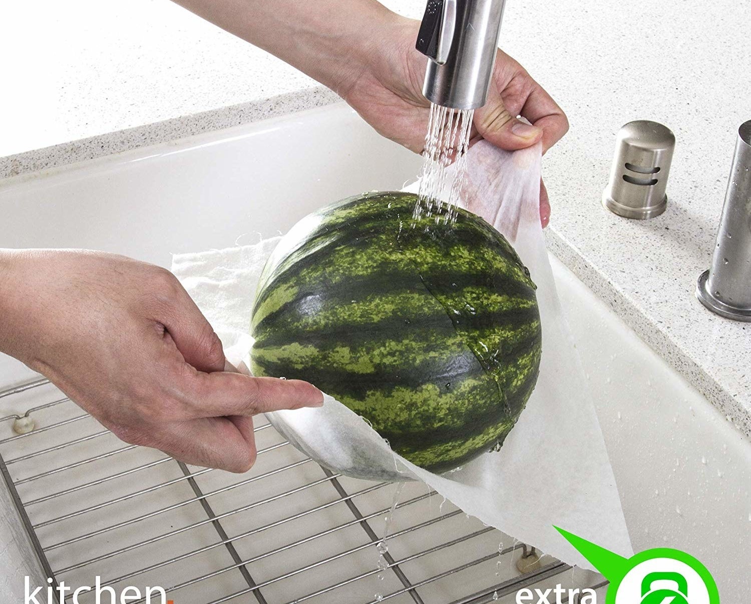 model holds a whole watermelon up under sink with paper towel 