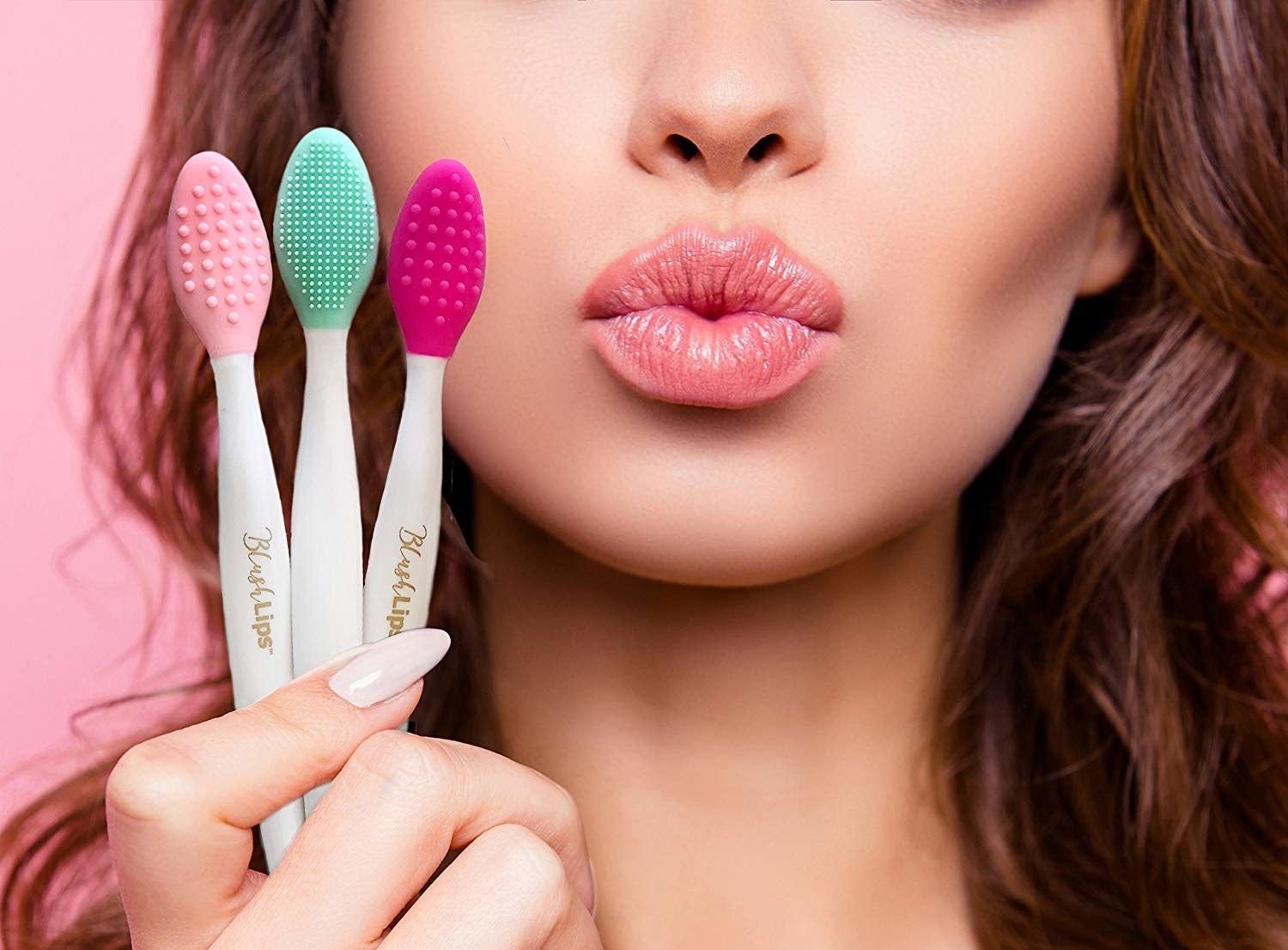 A model holding three lip scrubbing brushes