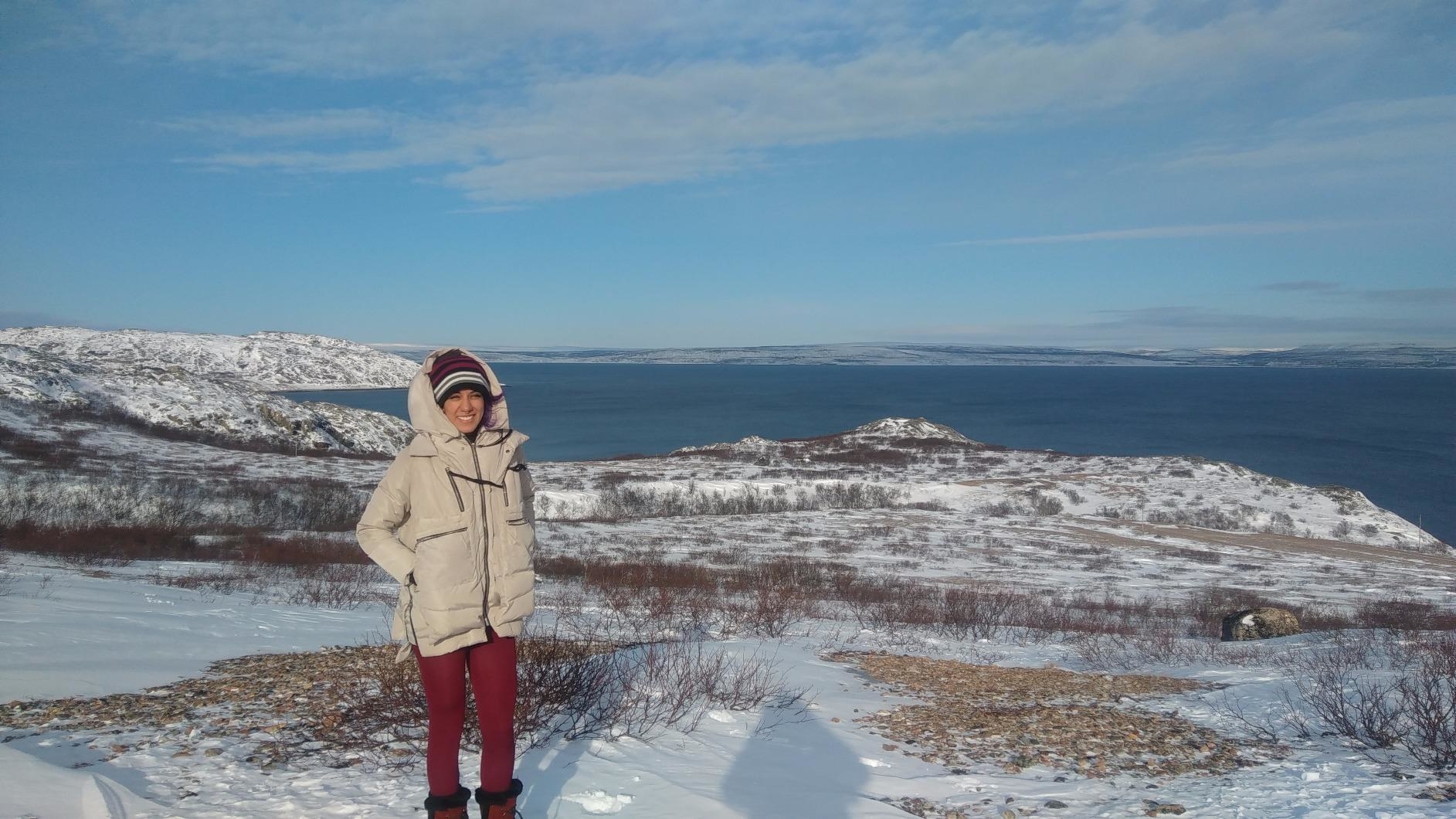 Reviewer in a snowy scene wearing the creamy beige coat