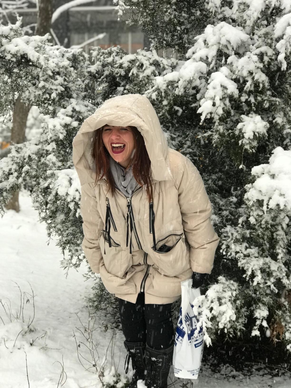 A reviewer wearing the cream-y beige coat with pockets in front unzipped