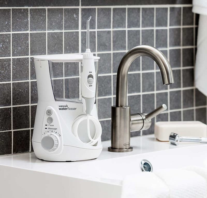 The flosser and its tank on a bathroom counter