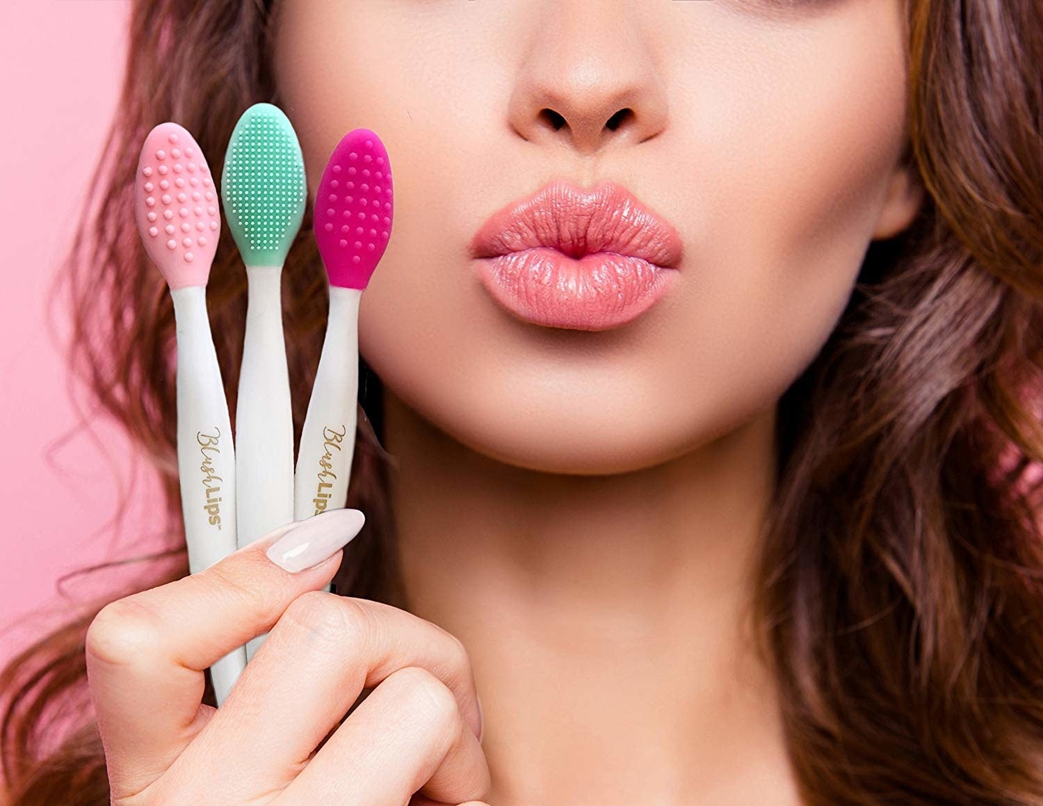 A model holding three brushes with textured silicone backs and puckering their lips