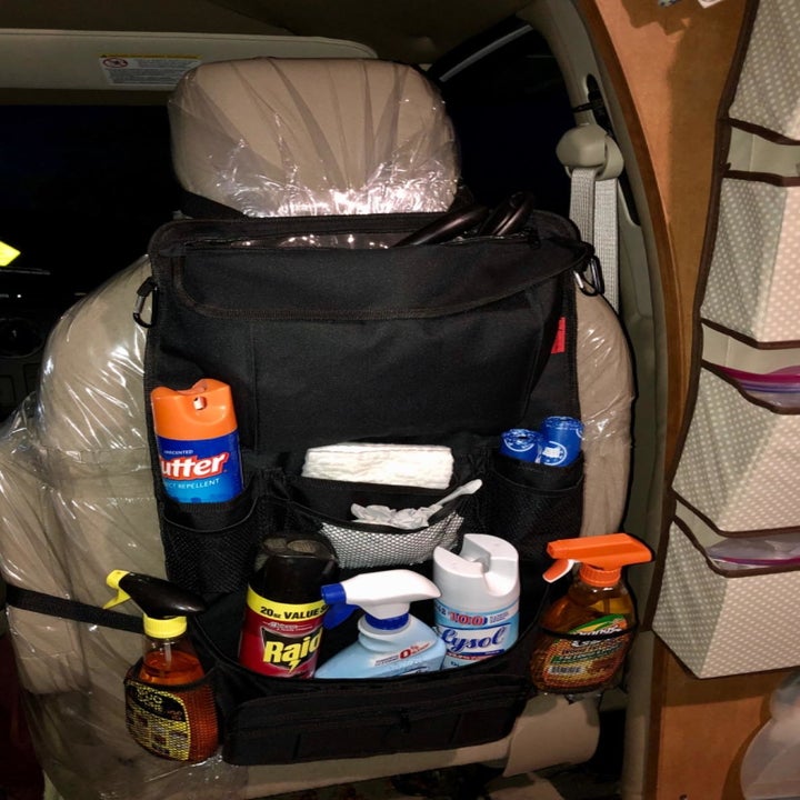 Reviewer photo of the organizer holding several bottles of cleaning supplies and bug spray bottles