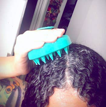 A reviewer using the teal brush on their scalp