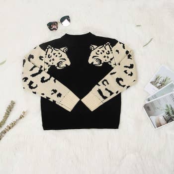 black sweater with white leopards on the sleeves