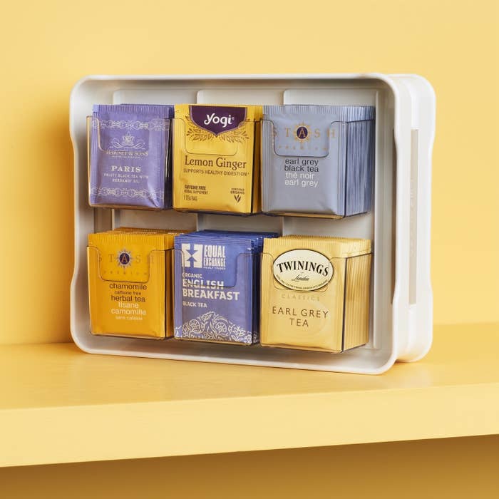 A large plastic panel with six pockets filled with different types of tea packages