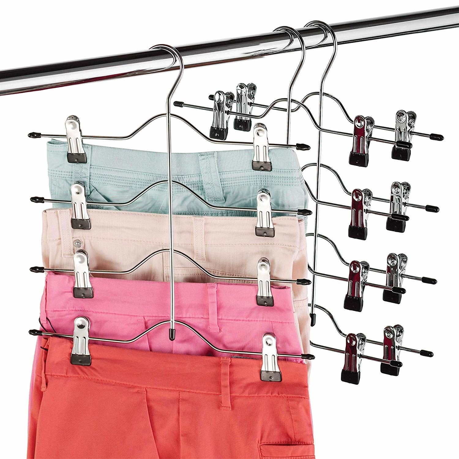 Four pairs of pants hanging from a hanger with clips on the ends