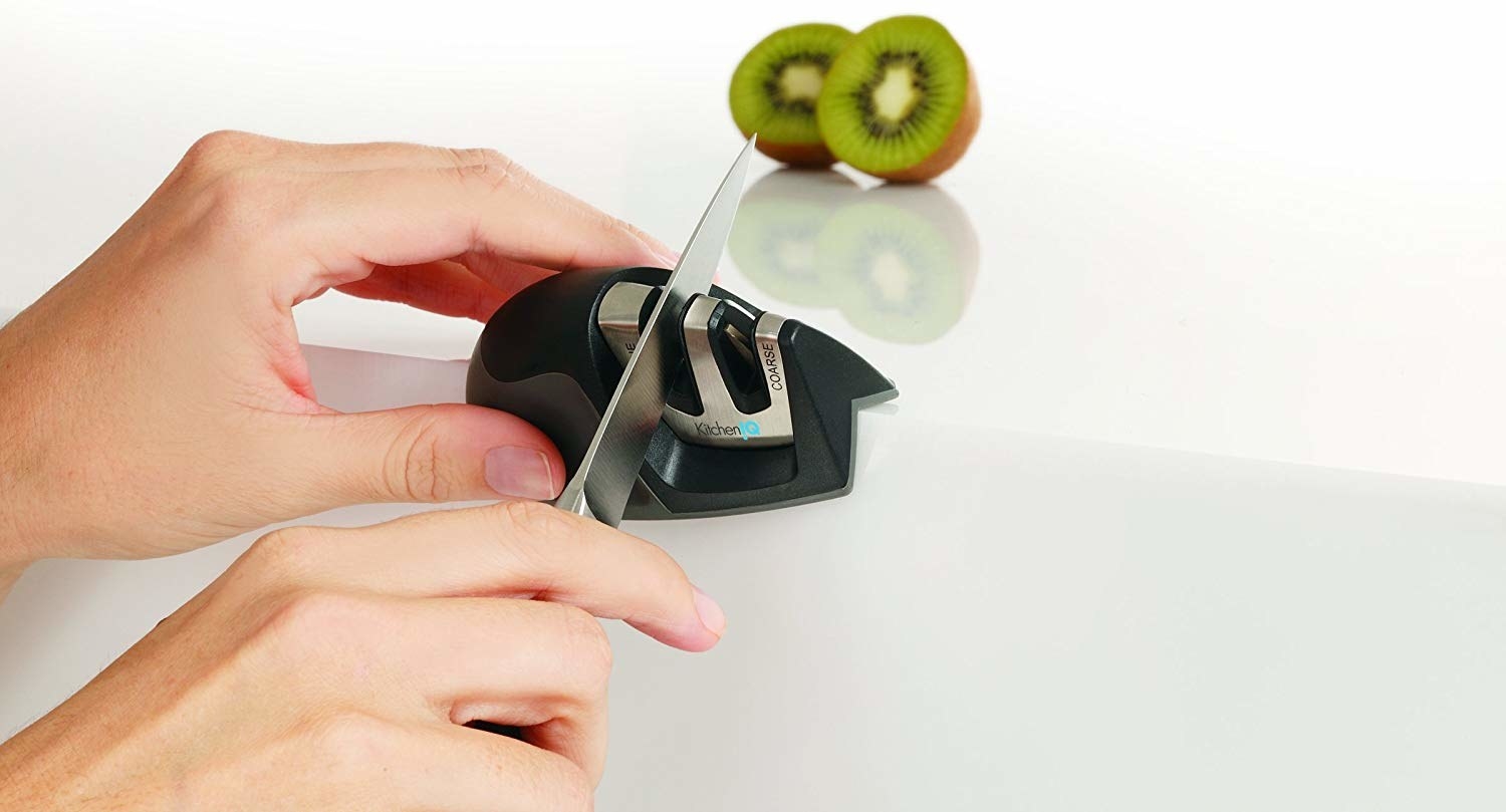 person pulling a knife through the small handheld knife sharpener
