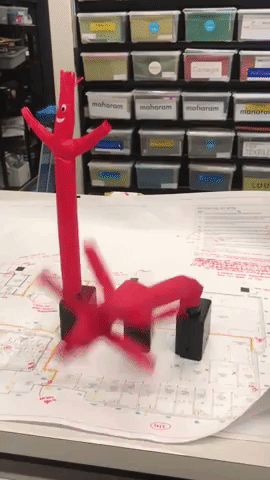 a gif of three of the red mini inflatable tube guys flopping around 