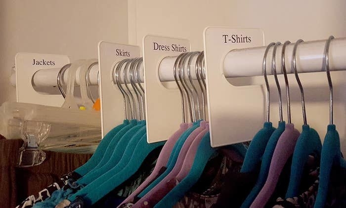a closet with their clothes divided by the labels, which read &quot;T-shirts, Dress Shirts, Skirts, and Jackets&quot; 