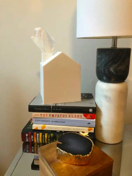 house-shaped white square tissue box cover on a stack of books