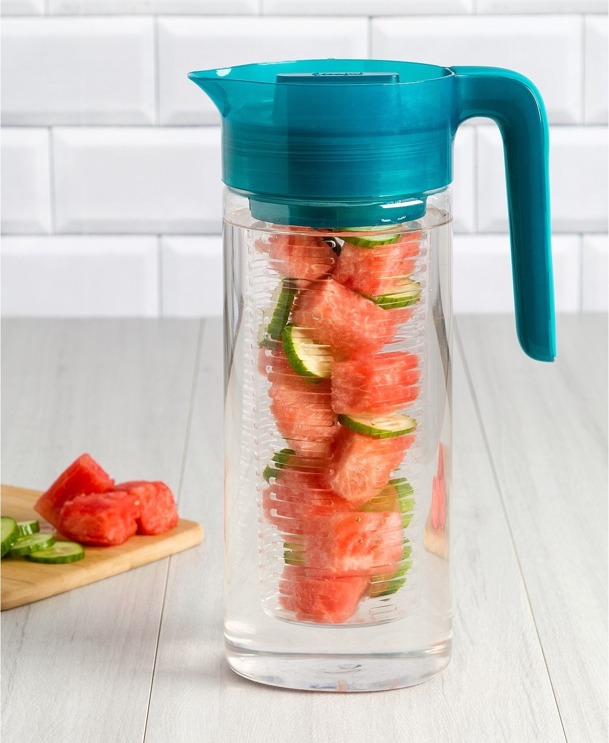 the clear water pitcher with a teal lid, filled with watermelon, cucumbers, and water 