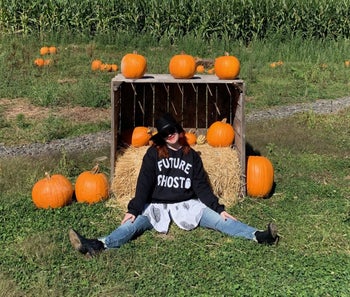 a buzzfeed writer in a pumpkin patch wearing the sweatshirt