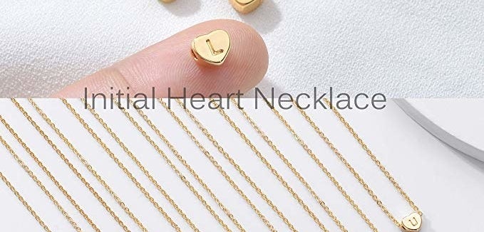 an array of the thin gold necklaces with gold hearts with initials in it