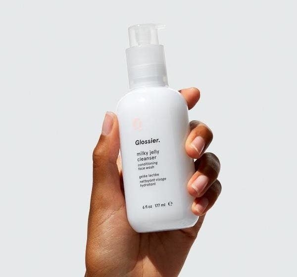 A person holding the milky jelly cleanser bottle