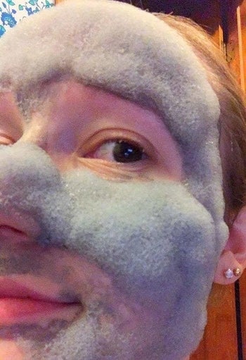 A reviewer showing how bubbly and foamy the mask is on their face