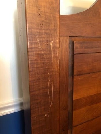 a reviewer's wooden bed frame with scratches on it