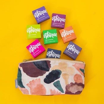 eight different ethique shampoo bars going into a toiletry bag