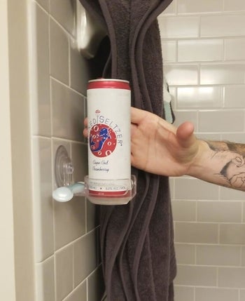 hard seltzer can sitting in a suction cup holder on shower wall