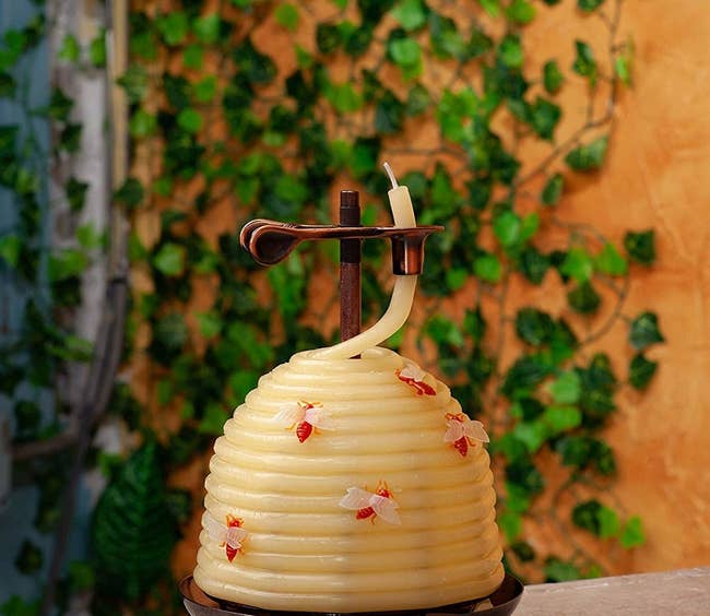 candle shaped like a beehive with plastic bees on it