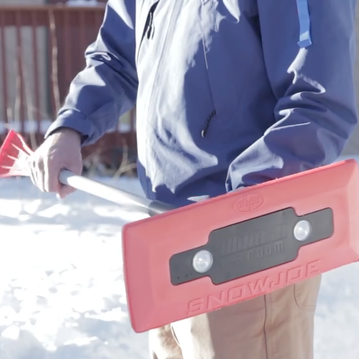 A reviewer holding the red snow broom
