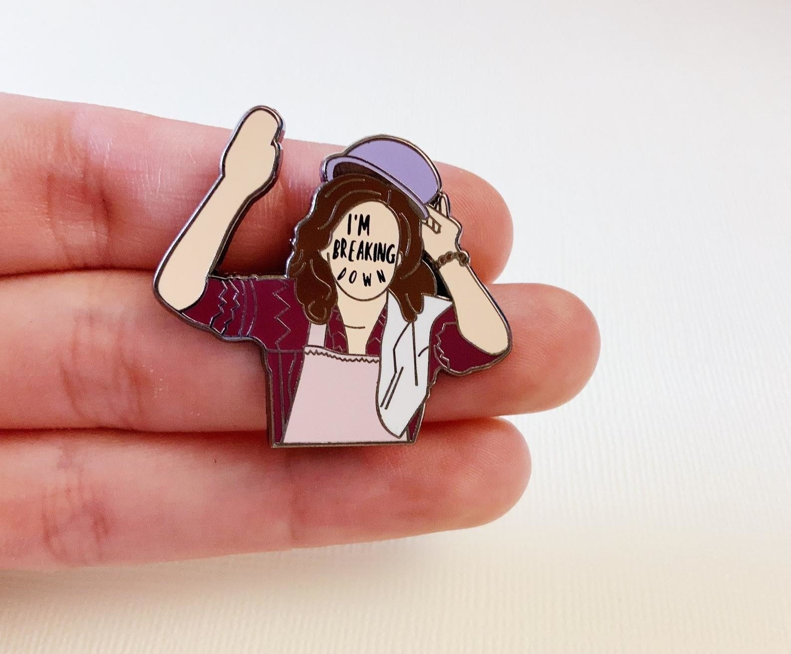 A pin of a woman raising their hand with the words I&#x27;m breaking down written on their face