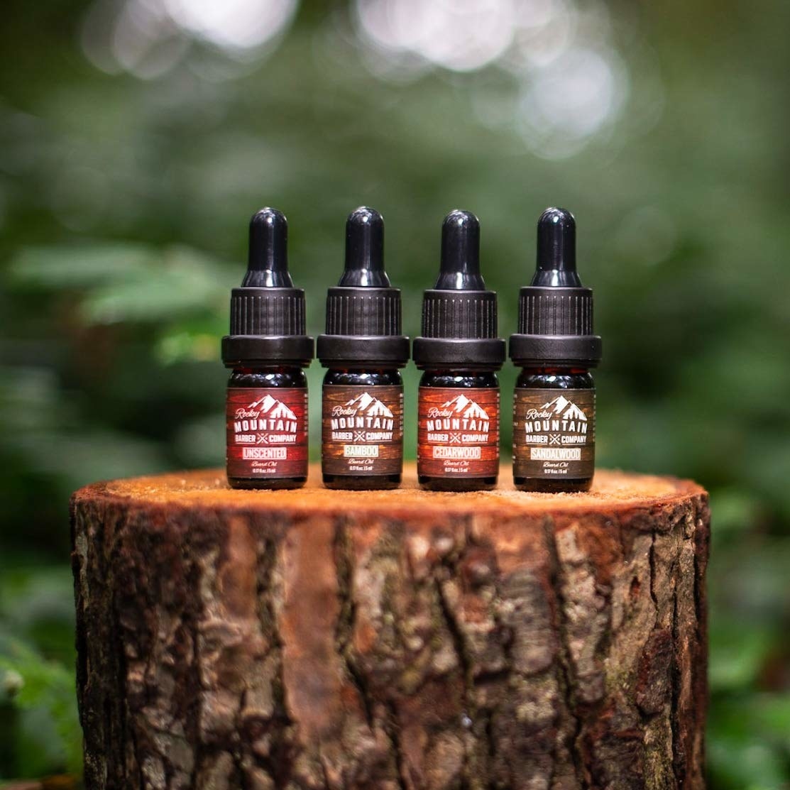 Four bear oils lined up on a stump