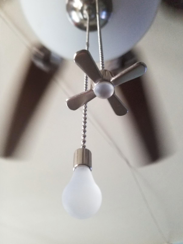 Reviewer image of the pull strings that have a bulb and fan attached to their ends