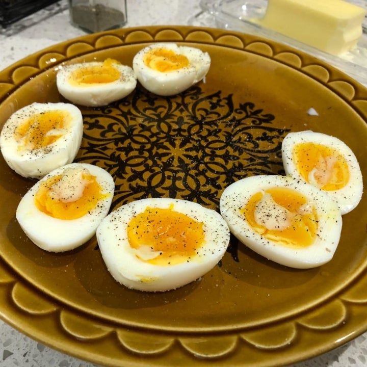 A reviewer showing soft-boiled eggs cut in half