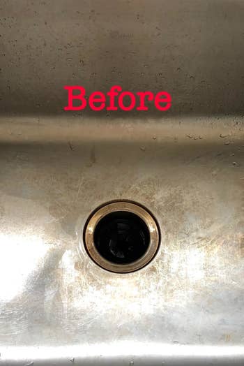 A reviewer's stainless steel sink with staining and the word 