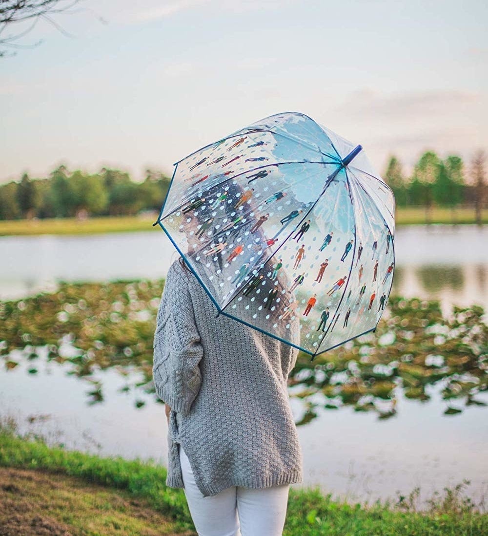 model under clear umbrella with illustrations of men and rain water 
