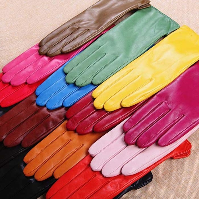 several gloves laid atop each other in different colors including orange, pink, fuchsia, red, black, burgundy, yellow, blue, and brown