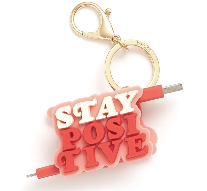 a charger that is pink and white and says "Stay Positive"