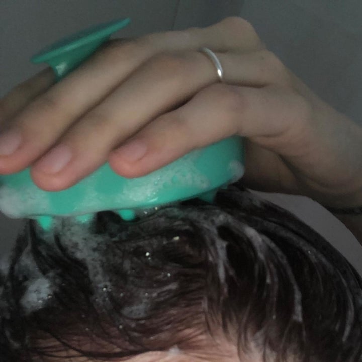 reviewer scrubbing their head with the massager 