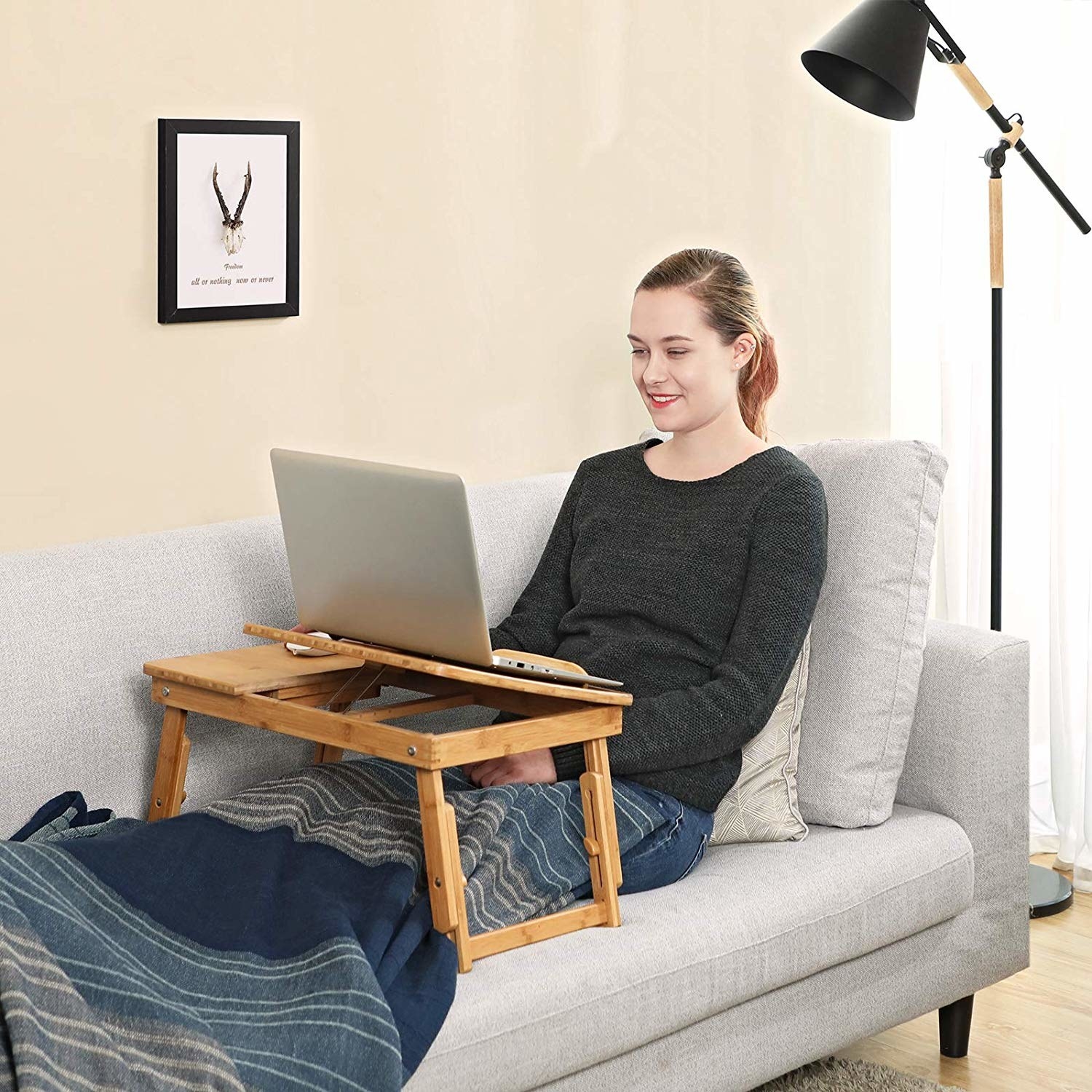 model using laptop desk on couch