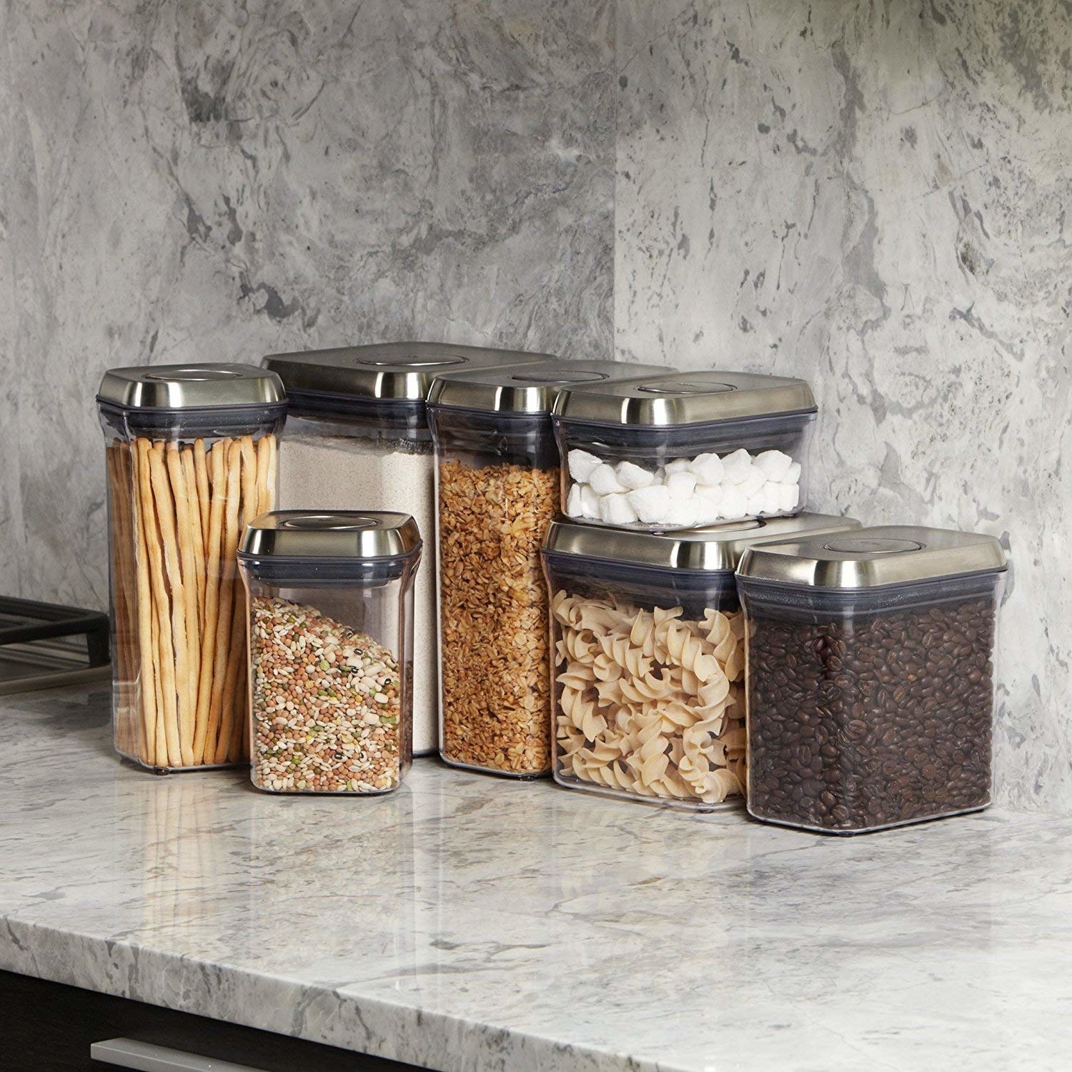 the clear canisters with silver lids on a counter 