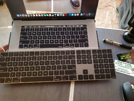 Large, flat keyboard in front of small laptop keyboard 