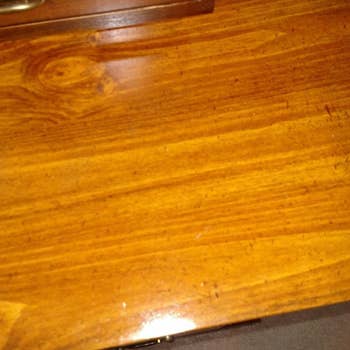 The same reviewer's wooden table looking shiny with no discoloration.