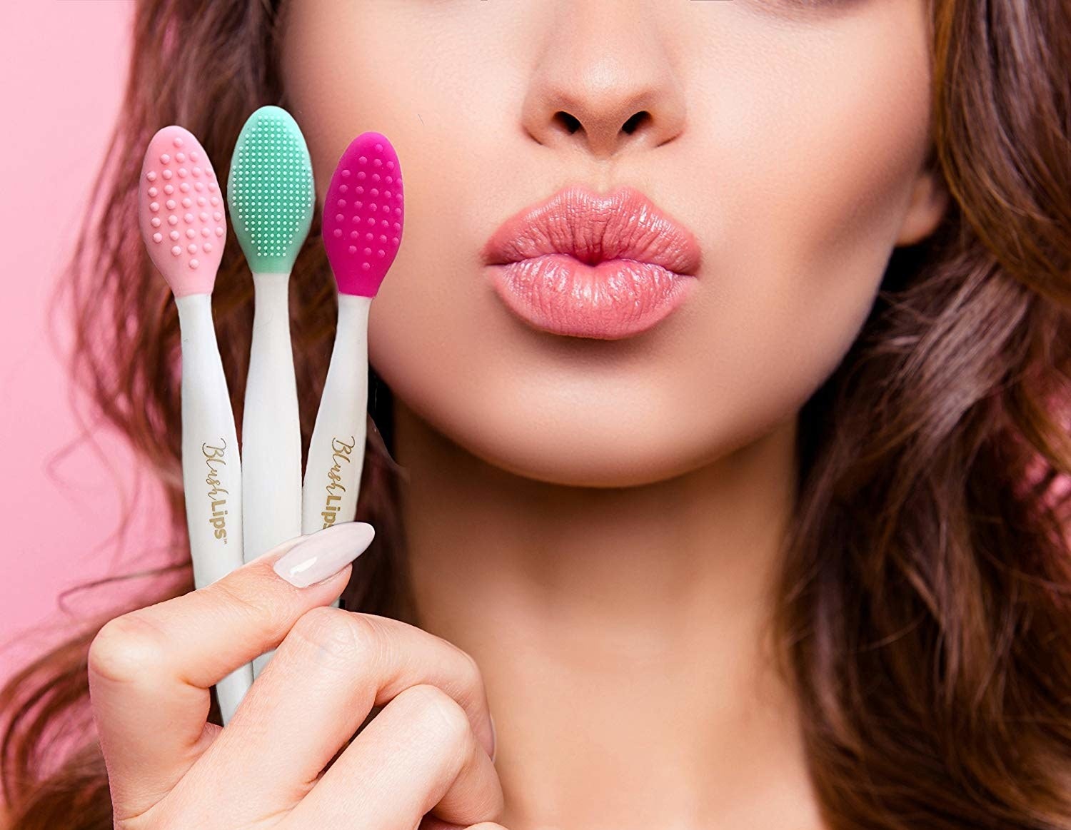 Person puckering lips while holding three toothbrush sized tools with silicone bumps for brushing lips 