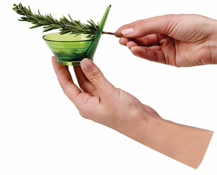 Hands pulling a twig of rosemary through the stripper