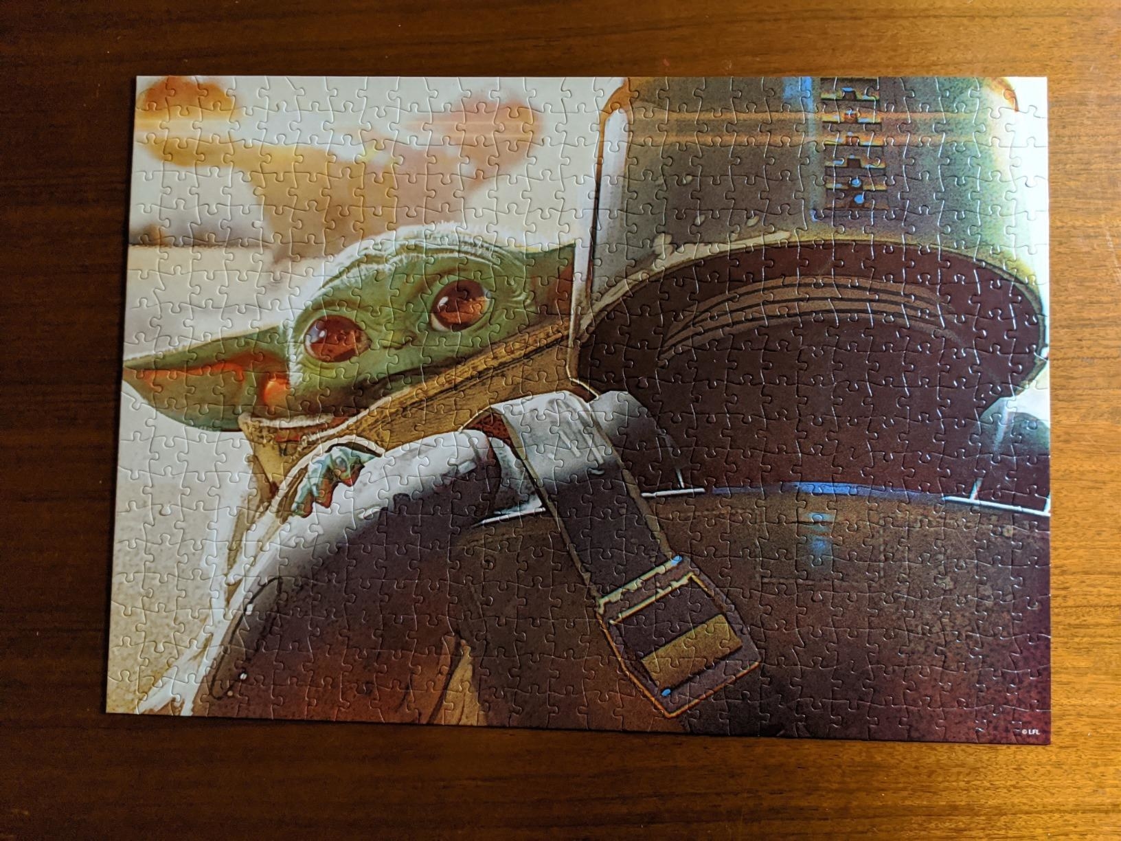 the assembled puzzle with the Mandalorian carrying Baby Yoda and Baby Yoda looking over his shoulder.