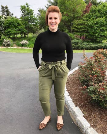 another reviewer wearing the olive pants with a black long-sleeve shirt and tan flats