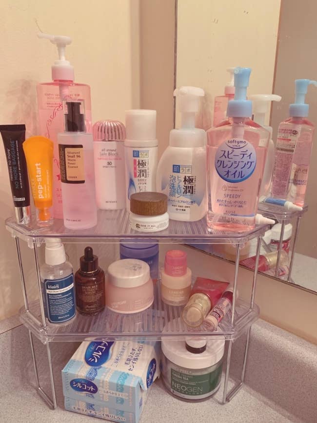 Reviewer image of the shelves stacked on top of each other and holding a variety of bathroom essentials