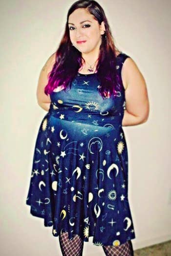 A reviewer wearing the dress in navy with a star, sun, and moon print