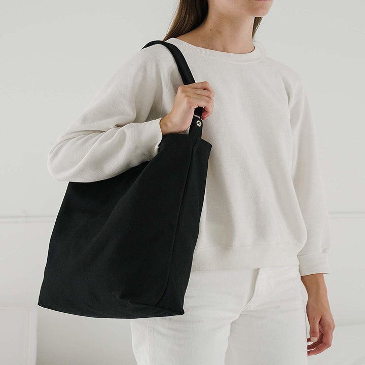 Black canvas tote thrown over model's shoulder 