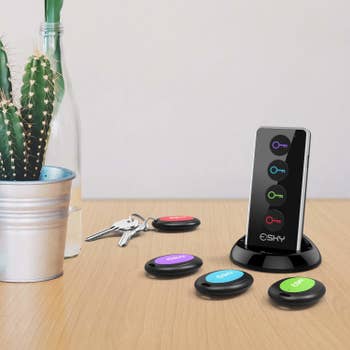 four oval trackers with different colors on each and a remote that pings each one