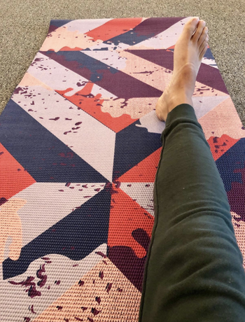 a reviewer stretched out on a colorful mat