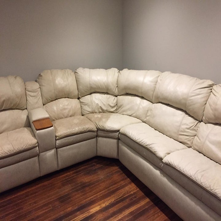 A reviewer showing white leather chairs that look darker and slightly brown on one side but brighter and cleaner on the side that was cleaned with the product