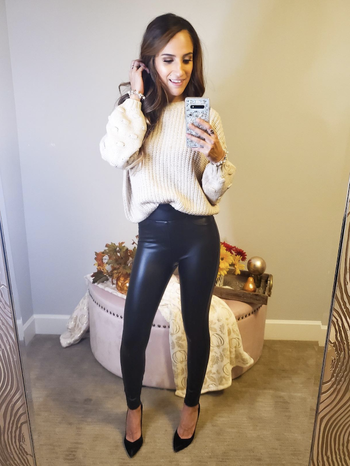 A reviewer wearing the faux leather leggings