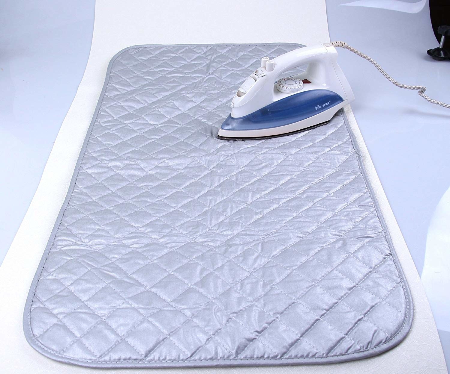 A thick quilted mat with an iron lying on it